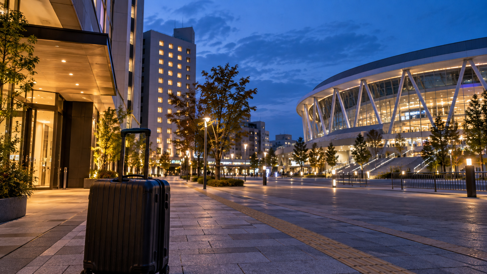 IGアリーナ遠征のホテル選びをイメージした名古屋の夜景とスーツケース